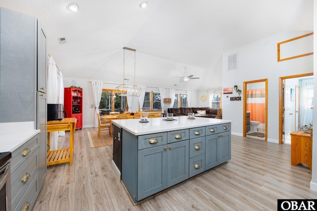 kitchen featuring a center island, pendant lighting, lofted ceiling, light countertops, and open floor plan