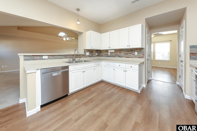 kitchen with pendant lighting, light countertops, stainless steel dishwasher, white cabinets, and a sink