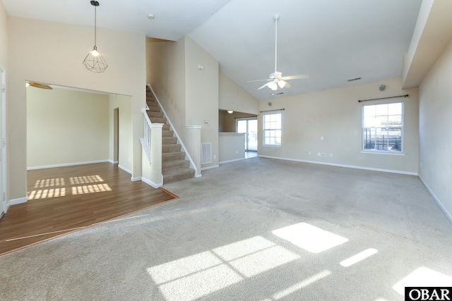 unfurnished living room with high vaulted ceiling, carpet floors, visible vents, baseboards, and stairway