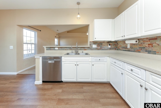 kitchen featuring decorative light fixtures, dishwasher, a sink, and white cabinetry