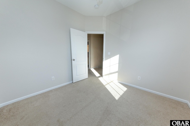 empty room with light colored carpet and baseboards