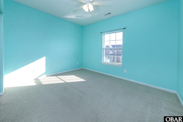 unfurnished room with ceiling fan, carpet floors, visible vents, and baseboards