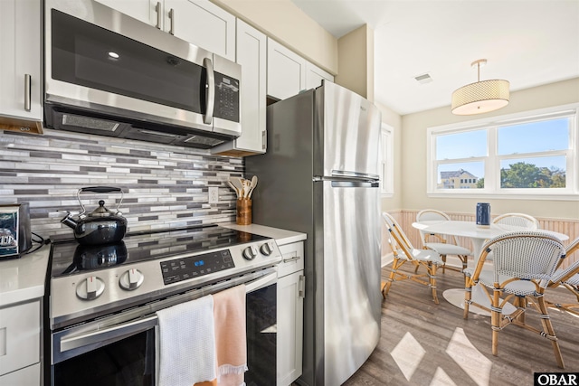 kitchen featuring visible vents, white cabinetry, light countertops, appliances with stainless steel finishes, and backsplash