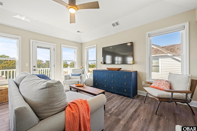 living room featuring plenty of natural light, visible vents, and dark wood-style flooring