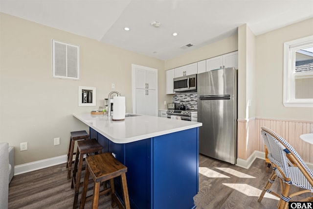 kitchen featuring stainless steel appliances, light countertops, visible vents, white cabinets, and a sink