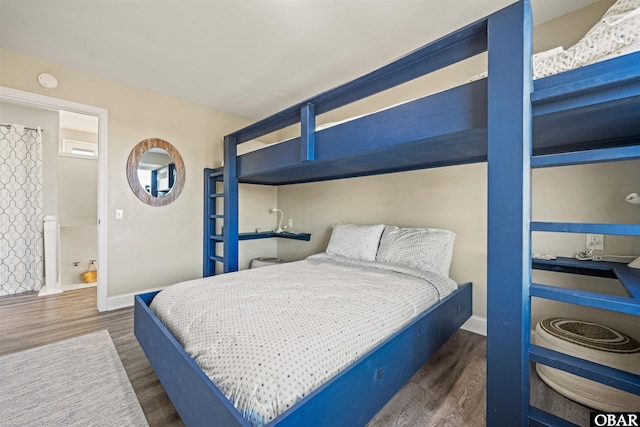 bedroom featuring baseboards and dark wood-type flooring