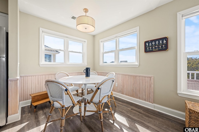 dining space with wainscoting, dark wood finished floors, and baseboards