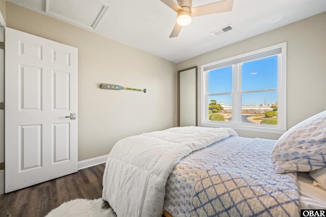 bedroom featuring attic access, visible vents, dark wood finished floors, a ceiling fan, and baseboards