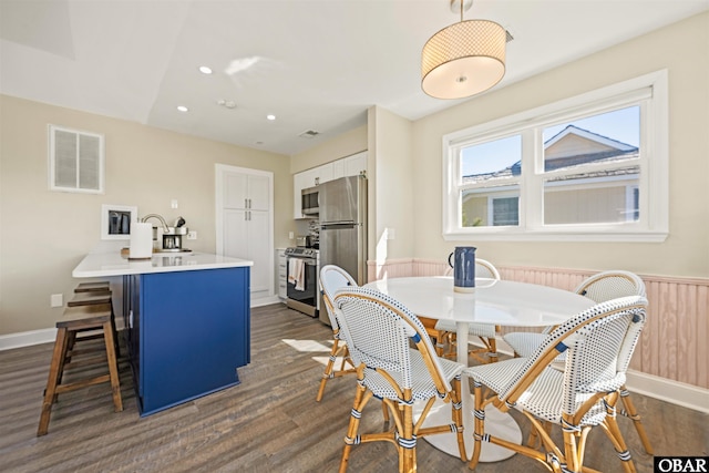 dining area featuring baseboards, visible vents, dark wood finished floors, a wainscoted wall, and recessed lighting