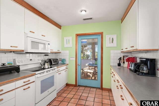 kitchen featuring visible vents, backsplash, white cabinetry, white appliances, and light tile patterned floors