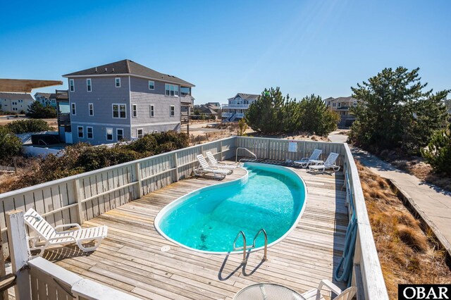 view of pool with a fenced in pool, a residential view, and a wooden deck