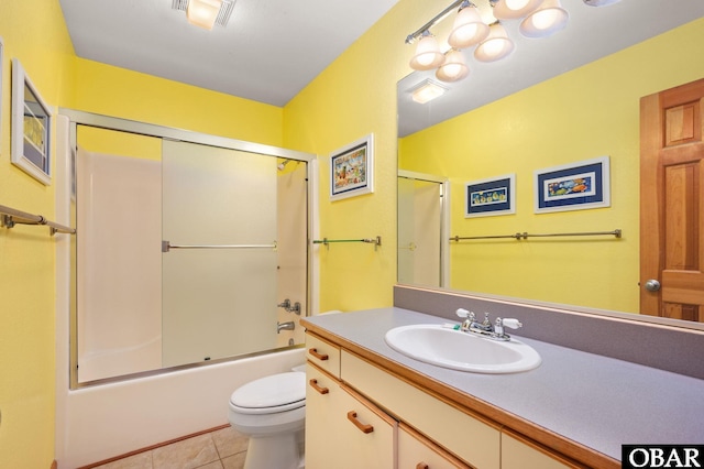 bathroom with tile patterned floors, visible vents, toilet, shower / bath combination with glass door, and vanity