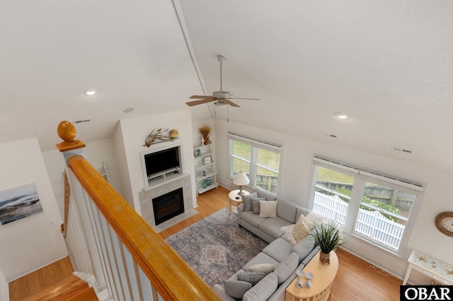 716 Moongate Ln Lot 51, Corolla, NC 27927 - living area featuring vaulted ceiling, a ceiling fan, wood finished floors, baseboards, and a tiled fireplace
