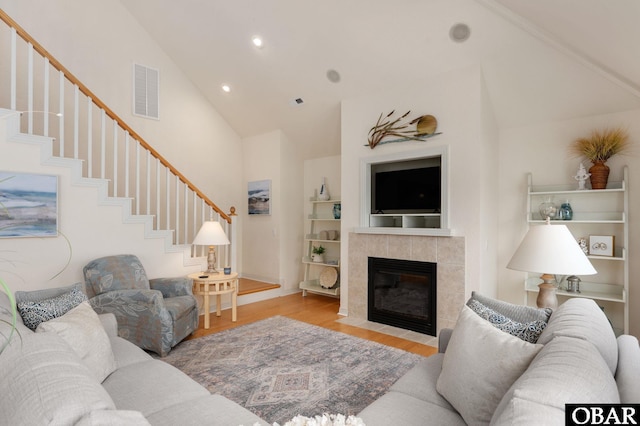 716 Moongate Ln Lot 51, Corolla, NC 27927 - living room featuring wood finished floors, stairs, a tile fireplace, high vaulted ceiling, and recessed lighting