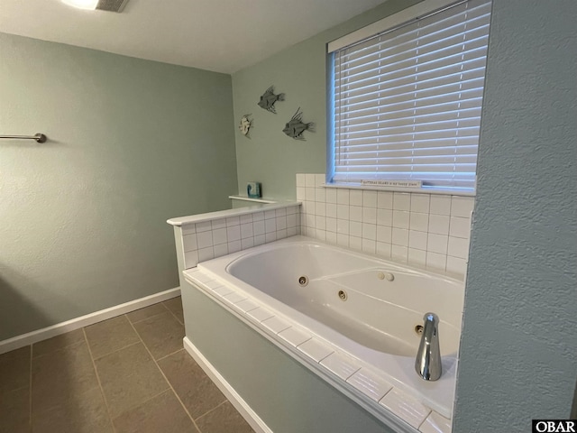 bathroom featuring baseboards, a textured wall, tile patterned flooring, and a jetted tub