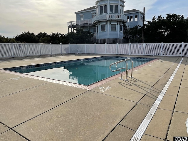 community pool featuring fence and a patio area