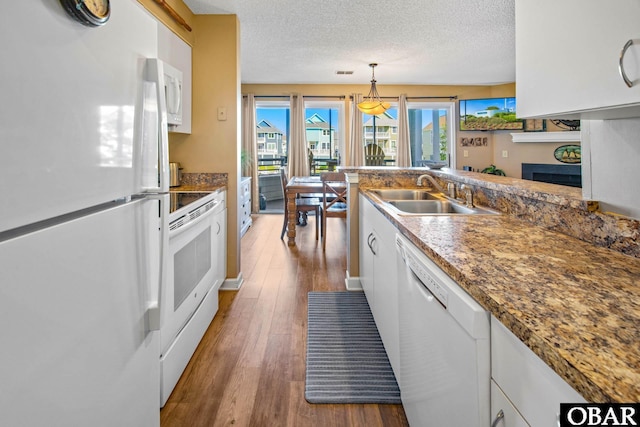 612 Pirates Way Unit # 612B, Manteo, NC 27954 - kitchen with white appliances, a sink, white cabinetry, wood finished floors, and a textured ceiling
