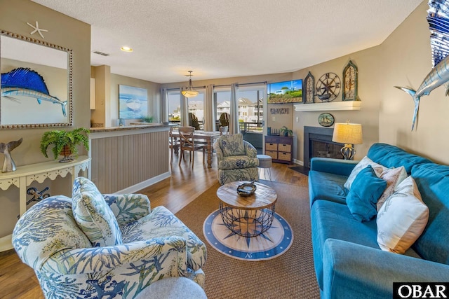 612 Pirates Way Unit # 612B, Manteo, NC 27954 - living area featuring wood finished floors, a textured ceiling, recessed lighting, a fireplace with flush hearth, and baseboards