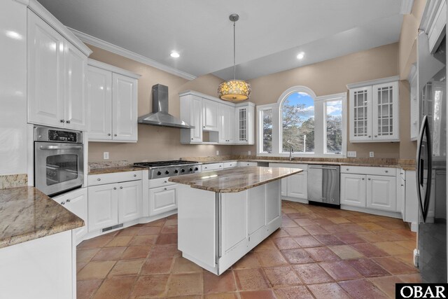 50336 Great Ridge Rd, Frisco, NC 27936 - kitchen with stainless steel appliances, white cabinets, glass insert cabinets, and wall chimney exhaust hood