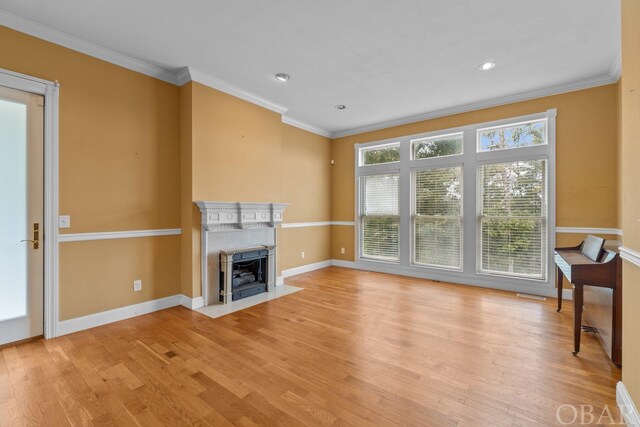 50336 Great Ridge Rd, Frisco, NC 27936 - unfurnished living room with crown molding, baseboards, a fireplace with flush hearth, and light wood-style floors