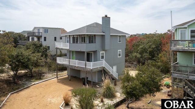 632 Grebe Ct Lot 9, Corolla, NC 27927 - back of property featuring a shingled roof, a chimney, a balcony, and stairway