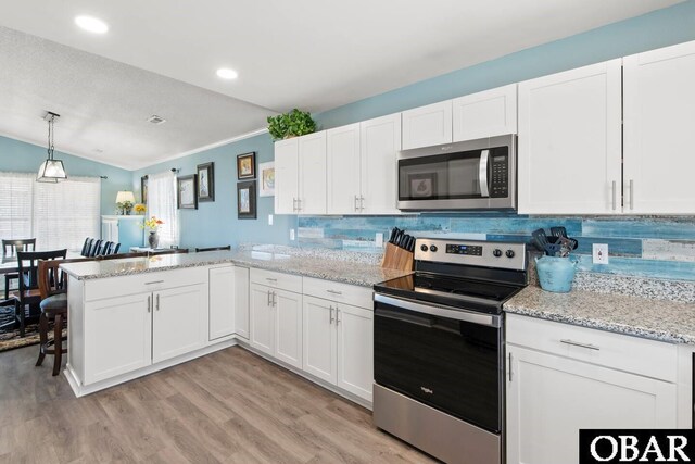 4023 Lindbergh Ave Lot # 65, Kitty Hawk, NC 27949 - kitchen with stainless steel appliances, a peninsula, white cabinets, light wood-style flooring, and vaulted ceiling