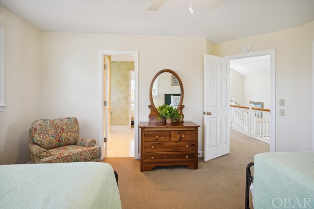 bedroom featuring a ceiling fan, connected bathroom, and light colored carpet