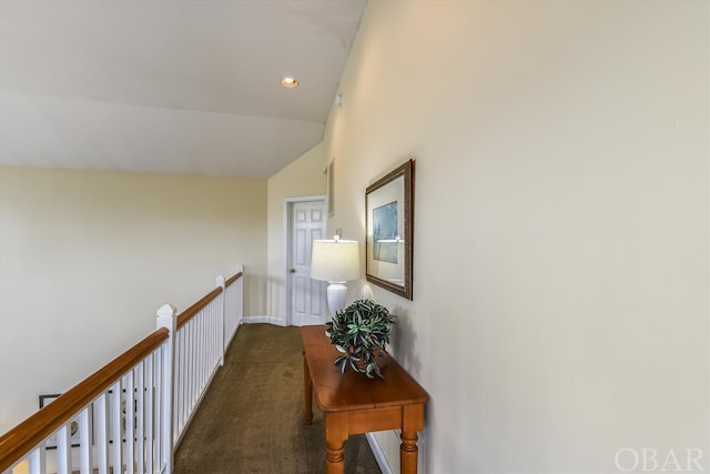 corridor with dark colored carpet, vaulted ceiling, baseboards, and recessed lighting