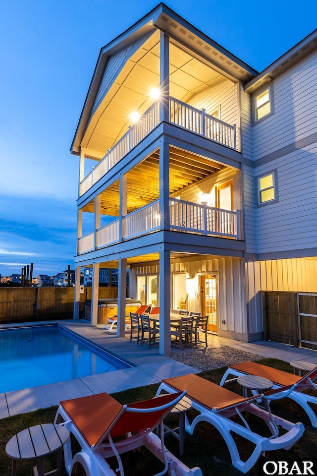 back of house with a fenced in pool, a patio, a balcony, and fence