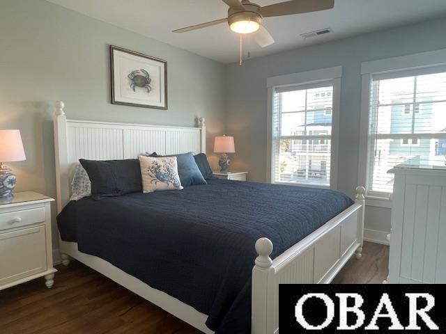 bedroom with baseboards, wood finished floors, visible vents, and a ceiling fan