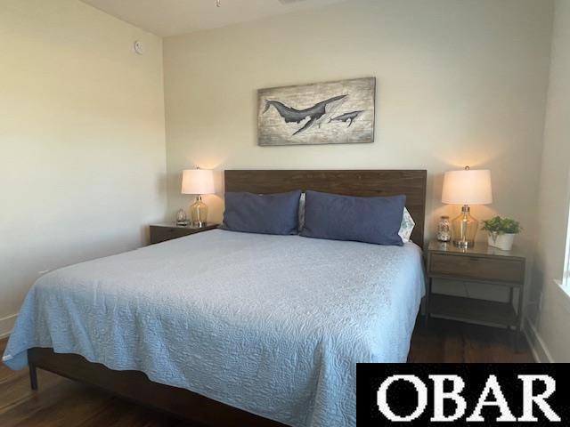 bedroom with wood finished floors and baseboards