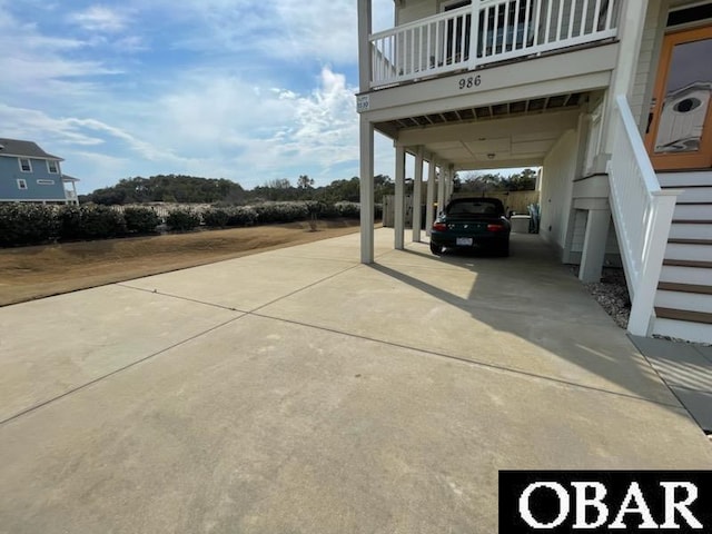 view of car parking featuring driveway and stairway