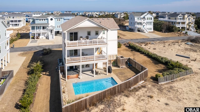 rear view of property featuring a residential view, a fenced backyard, a patio, and a balcony