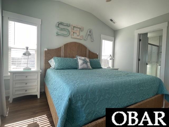 bedroom with vaulted ceiling, wood finished floors, and visible vents