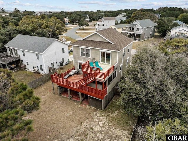 back of property with a shingled roof, fence, and a deck