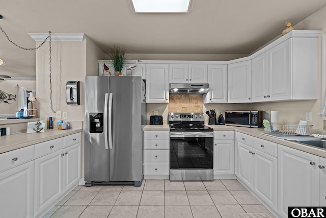 kitchen with light tile patterned flooring, under cabinet range hood, white cabinetry, light countertops, and appliances with stainless steel finishes