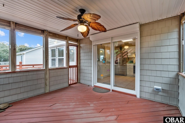 unfurnished sunroom featuring wood ceiling and a ceiling fan