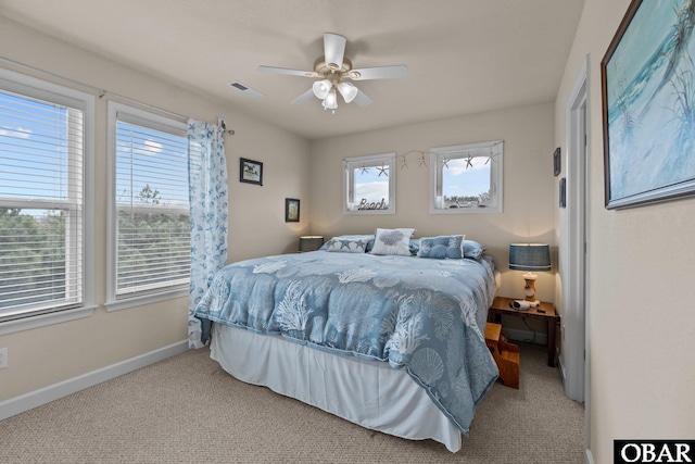 carpeted bedroom with a ceiling fan, visible vents, and baseboards