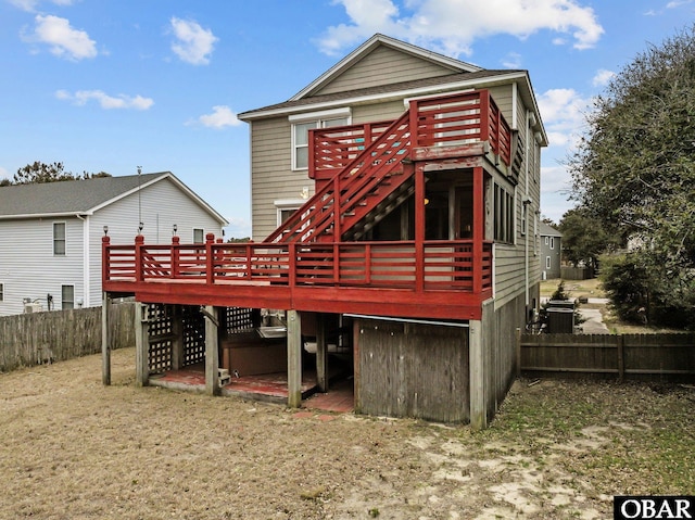 back of house featuring fence, a wooden deck, and stairs