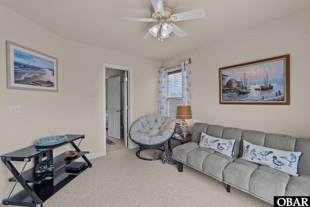 living area featuring carpet floors, baseboards, and a ceiling fan