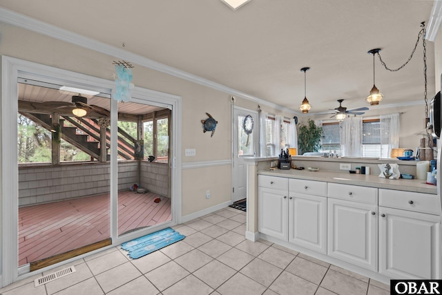 kitchen featuring visible vents, white cabinets, a ceiling fan, ornamental molding, and decorative light fixtures