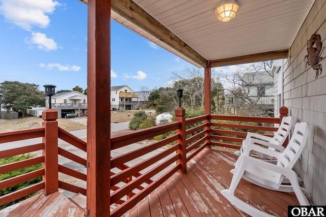 wooden terrace with covered porch and a residential view