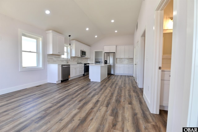 kitchen with pendant lighting, light countertops, appliances with stainless steel finishes, white cabinets, and a kitchen island