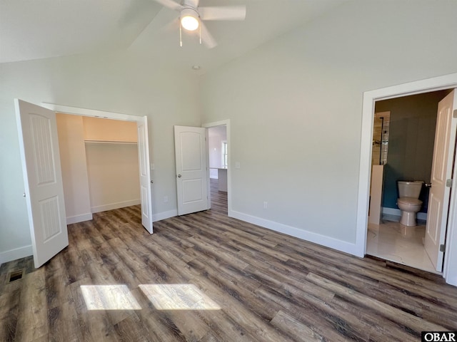 unfurnished bedroom featuring high vaulted ceiling, connected bathroom, wood finished floors, visible vents, and baseboards