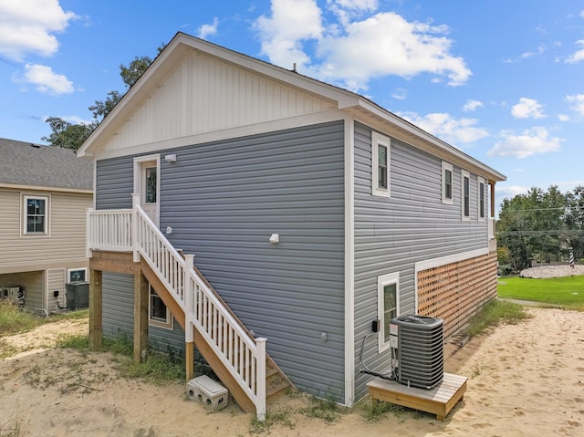 view of side of property featuring stairway and central AC unit