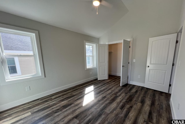 unfurnished bedroom featuring lofted ceiling, a closet, baseboards, and dark wood-type flooring