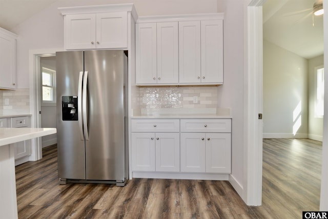 kitchen featuring dark wood finished floors, light countertops, decorative backsplash, white cabinets, and stainless steel fridge