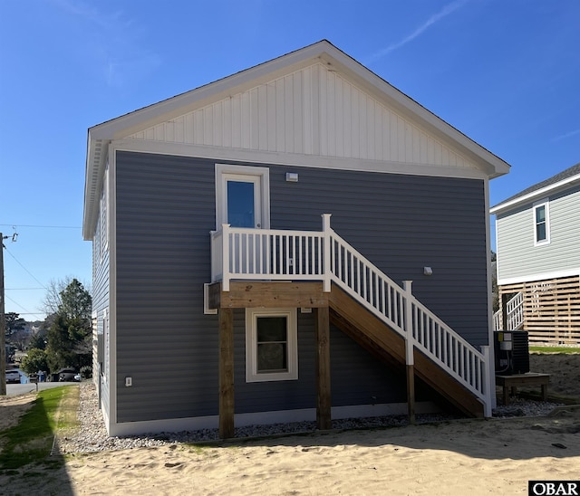 rear view of property featuring stairs and cooling unit