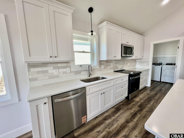 kitchen with washer and clothes dryer, stainless steel appliances, light countertops, white cabinets, and a sink