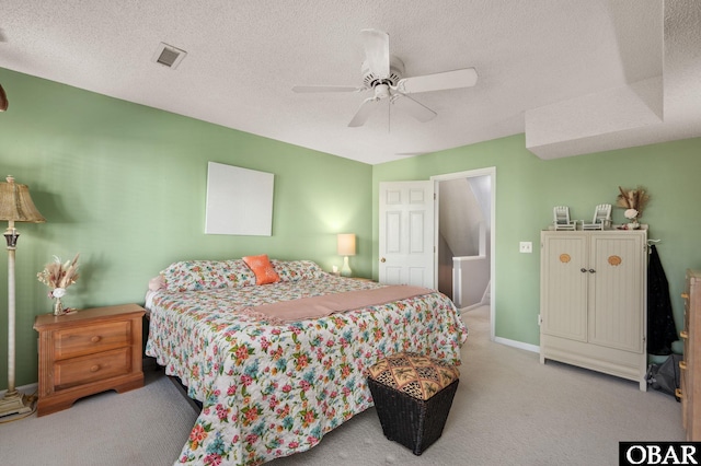 bedroom featuring visible vents, a ceiling fan, light carpet, a textured ceiling, and baseboards